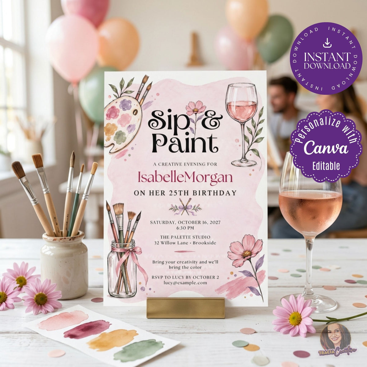 Sip and Paint birthday invitation with brushes, a paint palette, flowers and a wine glass, standing on a painting party table.